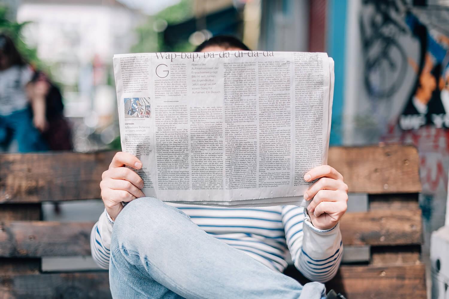 Person sitting with newspaper